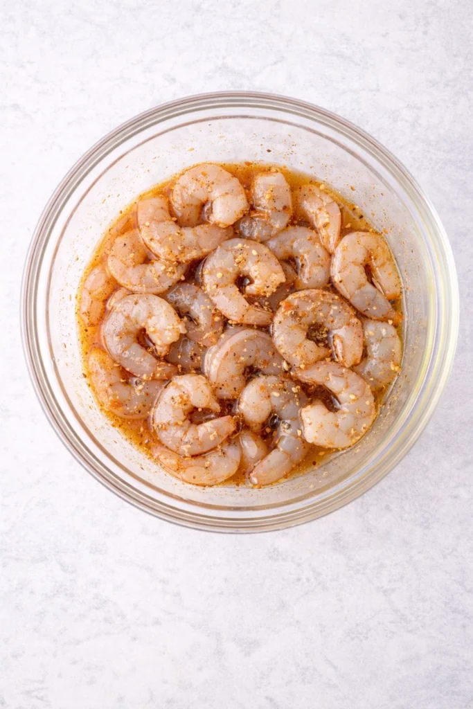 mixing the shrimp with the marinade 
