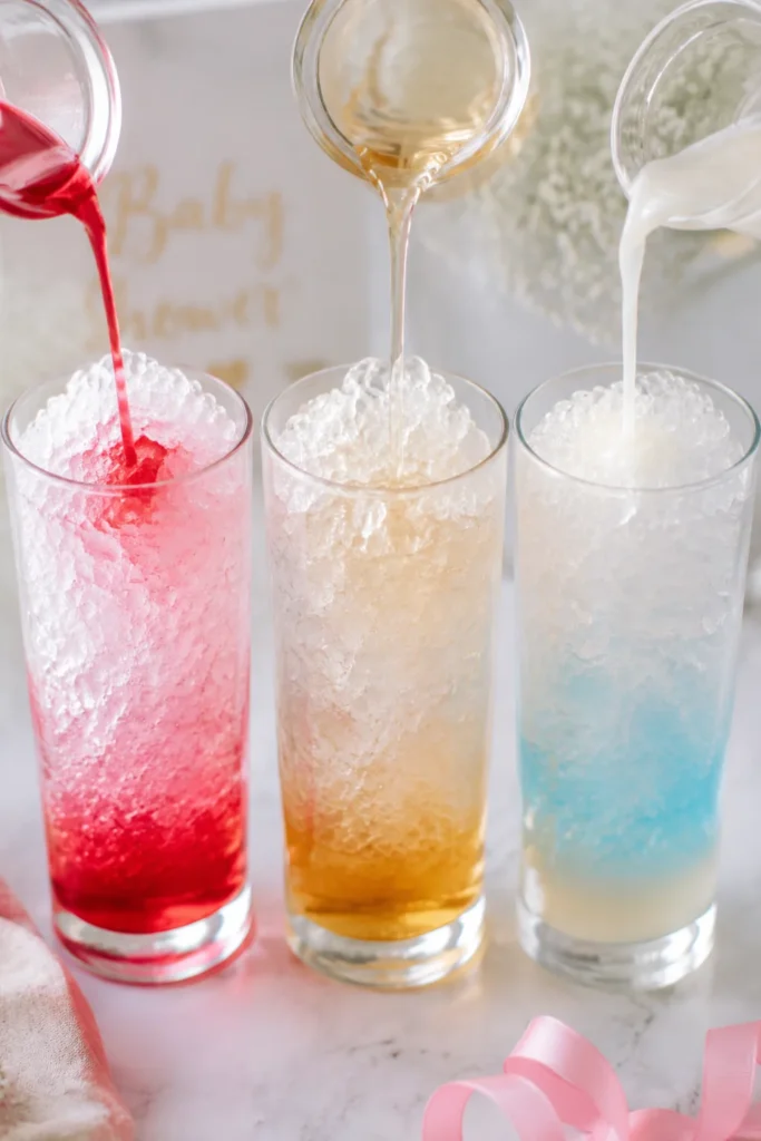“Pouring raspberry, vanilla, and coconut syrup over ice in a tall glass, colorful layers forming.”